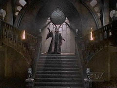 Image from Enemy Within showing The Master, descending the stairs in the Cloister Room